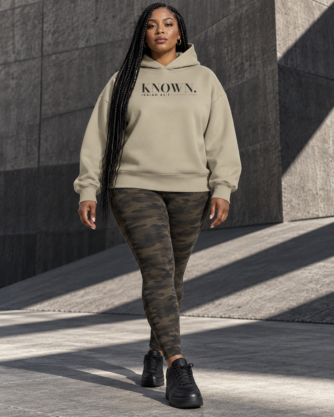 Woman wearing the Stone KNOWN. structured heavyweight hoodie with charcoal chest artwork.