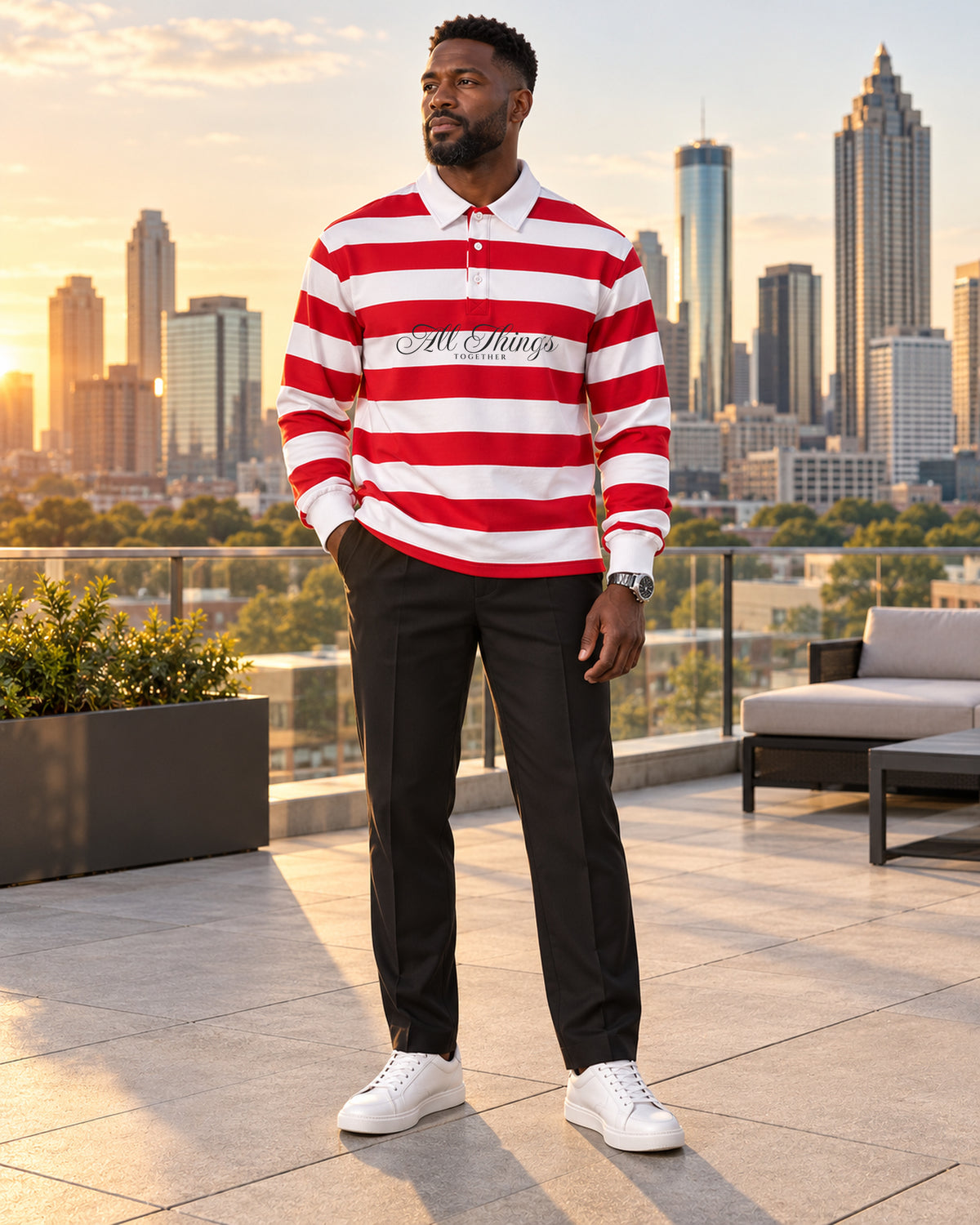 Red and white rugby polo styled with black tailored trousers and white sneakers on a city rooftop
