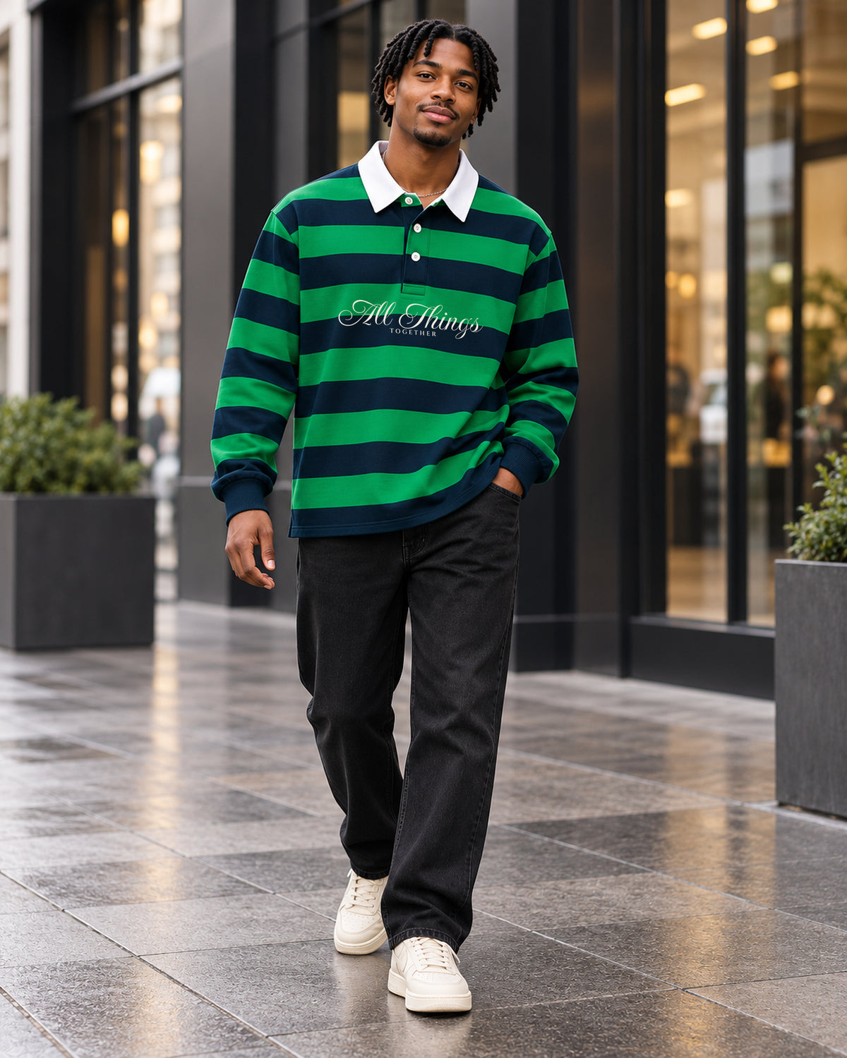 Green and navy rugby polo styled with dark denim and cream sneakers in a modern shopping district