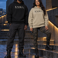 Couple wearing KNOWN. structured heavyweight hoodies in Stone and Black, with clean fronts, no pockets and no drawstrings.