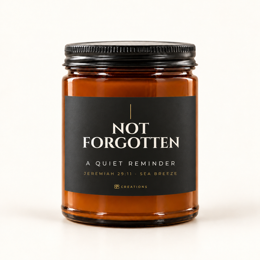828 Creations NOT FORGOTTEN Charcoal Sea Breeze candle in amber glass with black matte lid and Jeremiah 29:11 · Sea Breeze label.