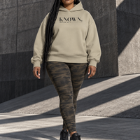 Woman wearing the Stone KNOWN. structured heavyweight hoodie with charcoal chest artwork.