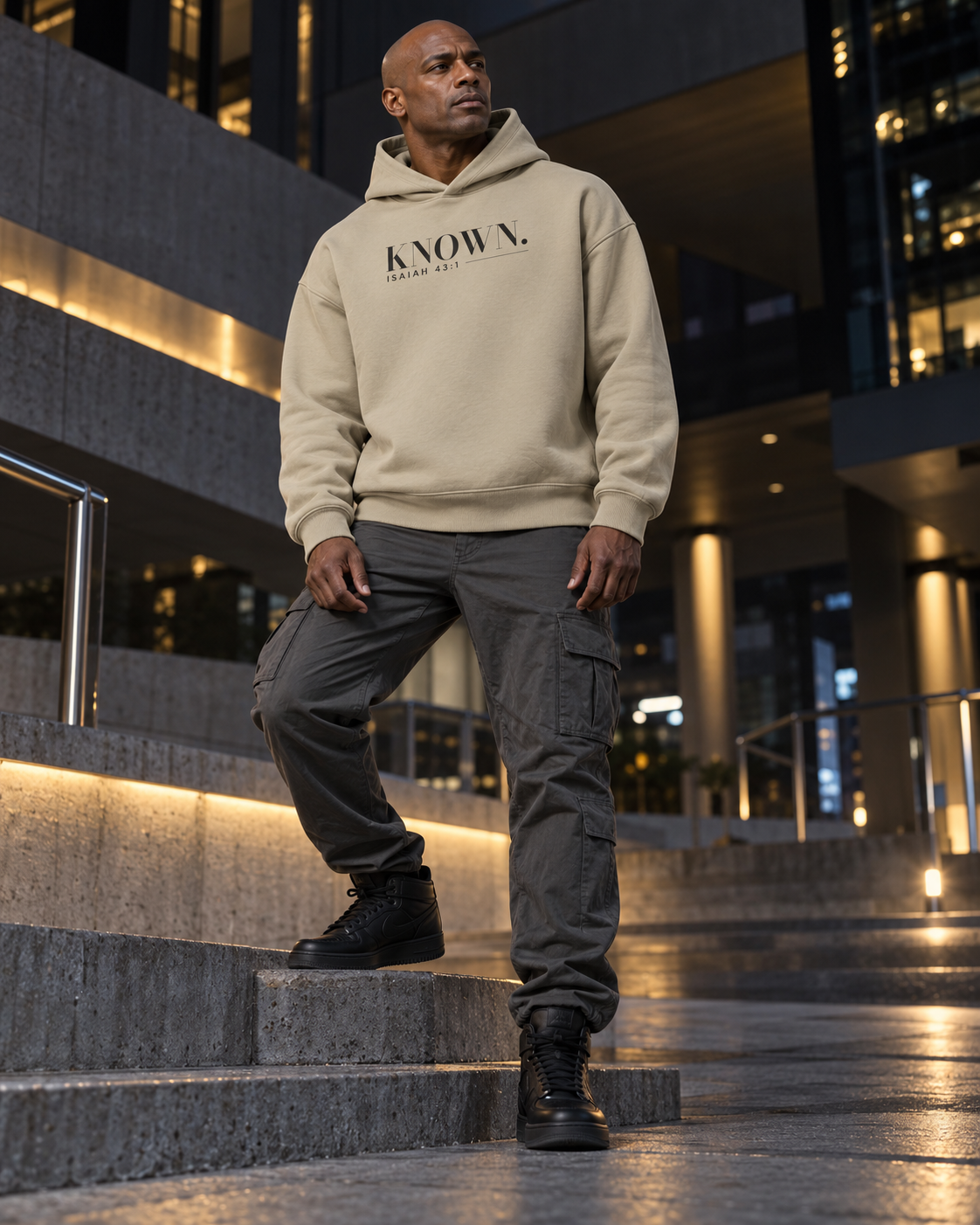 Man wearing the Stone KNOWN. structured heavyweight hoodie with charcoal chest artwork.