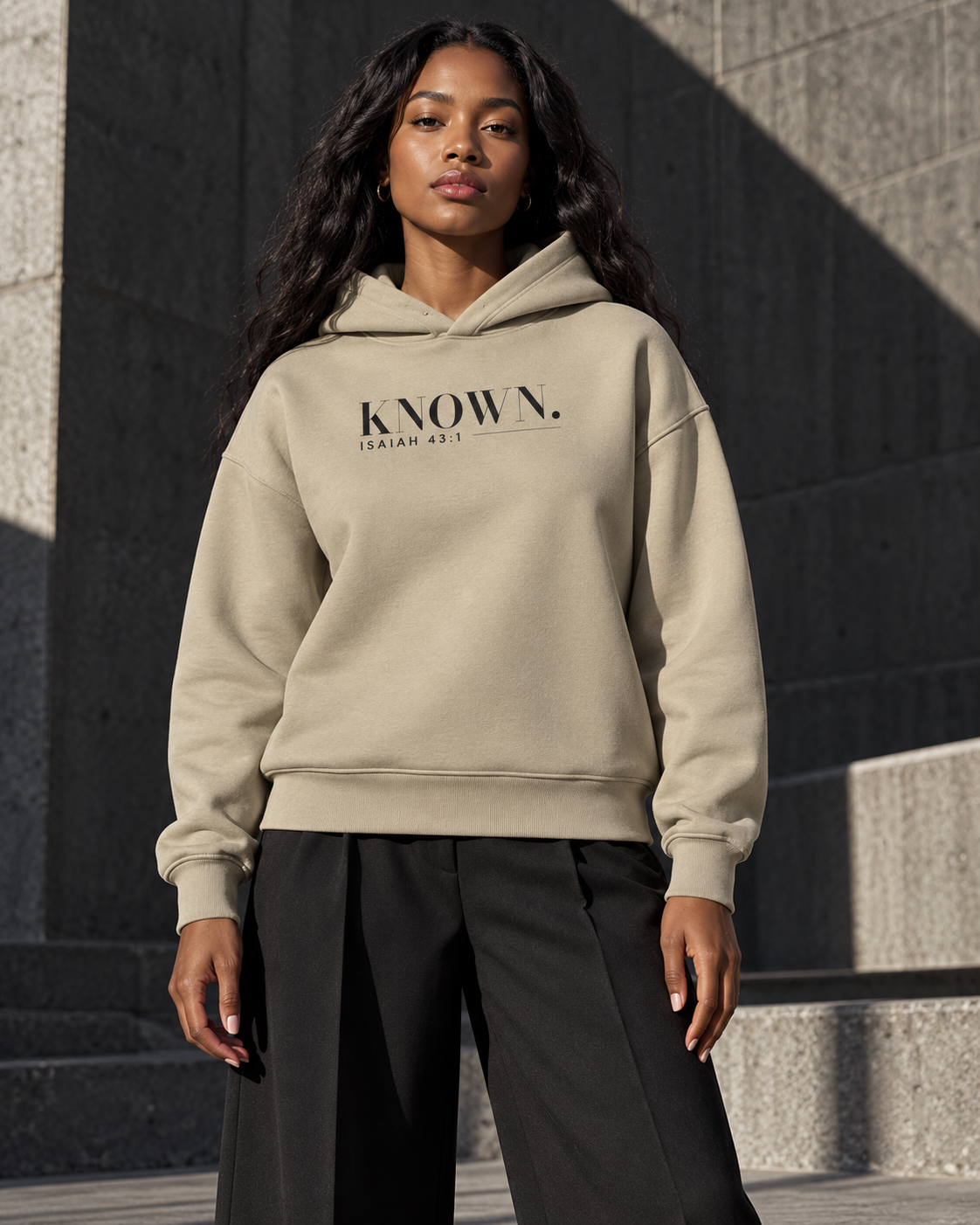 Woman styled in the Stone KNOWN. heavyweight hoodie, showing its clean front and structured hood.