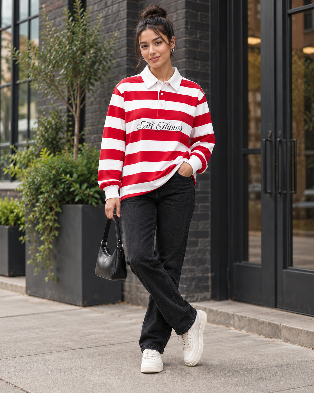 Red and white rugby polo styled with black denim, cream sneakers and a small handbag