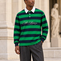 Green and navy rugby polo front styled with charcoal trousers outside a gallery