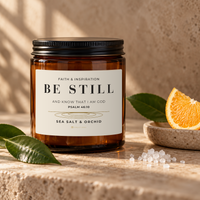BE STILL Sea Salt & Orchid candle by 828 Creations styled with sea salt, green leaves and an orange slice.
