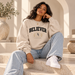 Woman styling the BELIEVER IDENTITY Snow Washed Oversized Sweatshirt in Light Apricot by 828 Creations