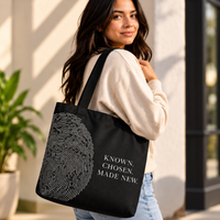 Woman carrying the black Believer Identity large tote with oversized fingerprint artwork and Known. Chosen. Made New. design