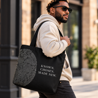 Man styling the black Believer Identity large tote with fingerprint artwork and black shoulder handles