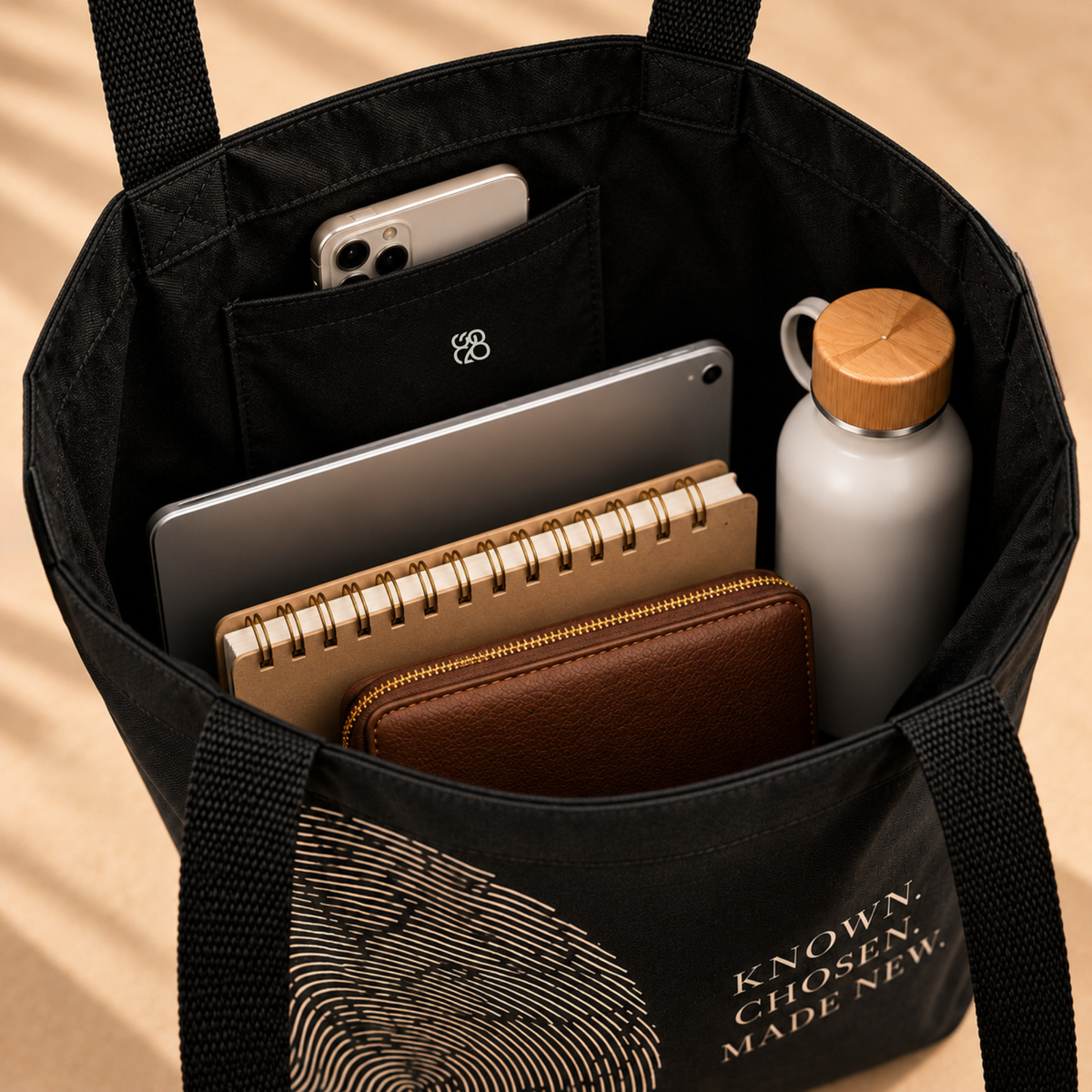 Open Believer Identity large tote showing roomy main compartment with tablet, notebook, wallet, water bottle and inside pocket