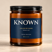 828 Creations KNOWN Isaiah 43:1 Fresh Balsam candle in amber glass with a midnight-navy label and fine-ridged black lid on a neutral background.