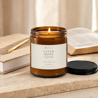 Lit FAITH HOPE LOVE Sea Breeze candle styled with a journal, Bible, and gold pen