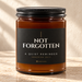 828 Creations NOT FORGOTTEN Jeremiah 29:11 Charcoal candle in amber glass with a matte black ribbed lid, styled on warm stone with the approved smaller title and tiny maker mark.