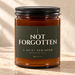 828 Creations NOT FORGOTTEN Jeremiah 29:11 Sea Breeze candle in Deep Olive, with an amber glass jar and ribbed black lid, styled in warm sunlight.