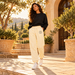 Woman wearing BELIEVER IDENTITY Cream Apricot sweatpants with Black BI emblem and black top
