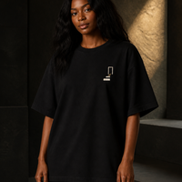 Woman wearing THE REMNANT oversized heavyweight black T-shirt with the Returning Stone chest symbol